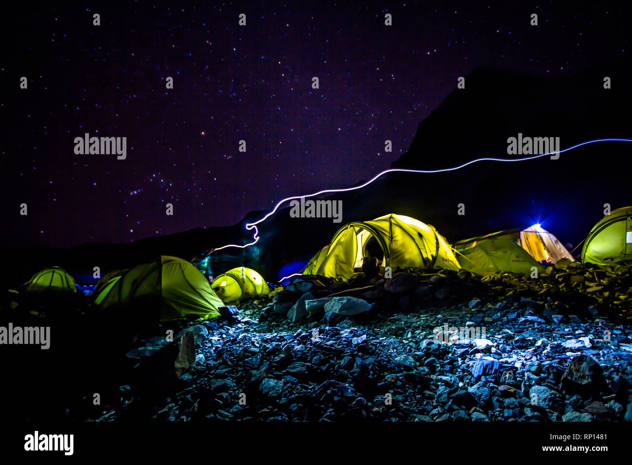Una lunga esposizione dei partecipanti al Campo Base Everest cattura un alpinisti torcia da testa a piedi per una tenda, Nepal Foto Stock