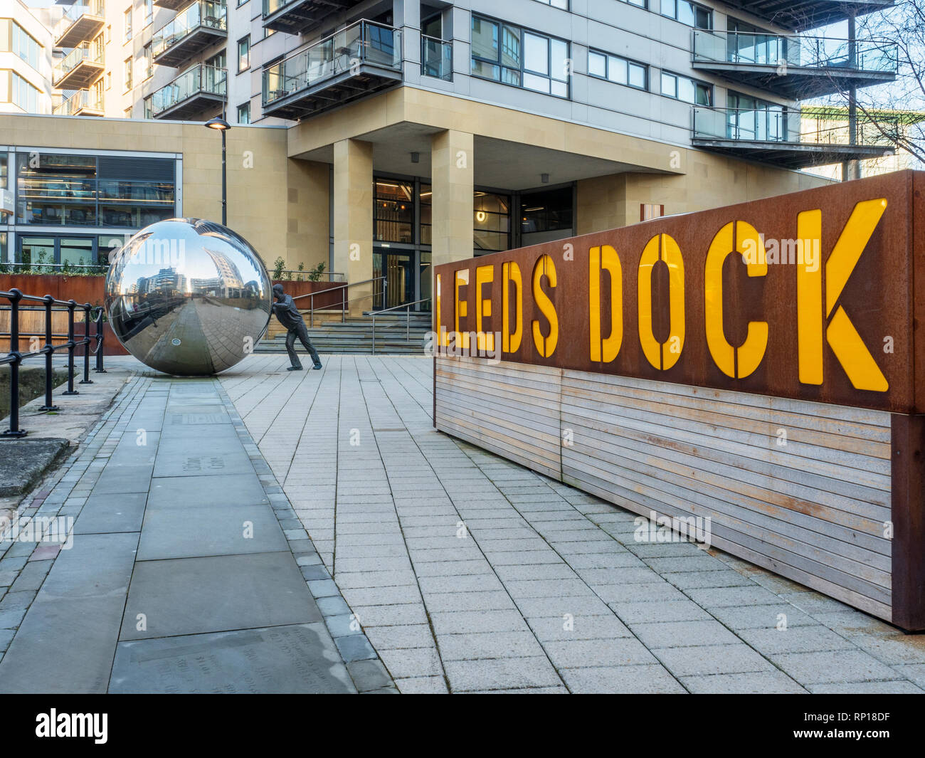 Un approccio riflettente scultura moderna di Kevin Atherton e Leeds Dock segno a Leeds Dock West Yorkshire Inghilterra Foto Stock