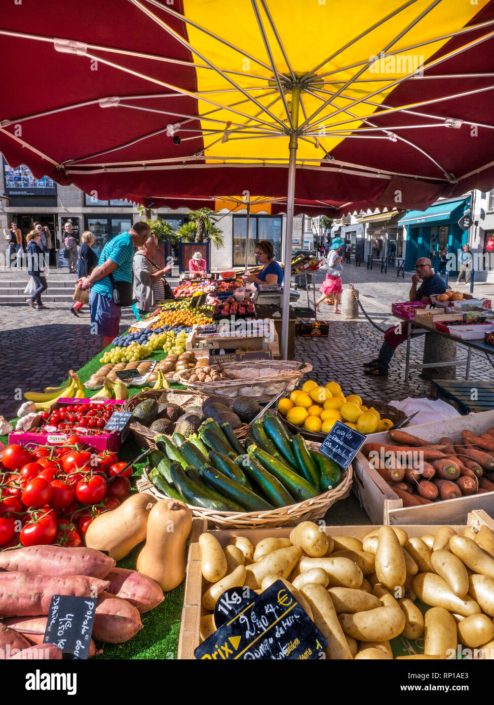 MERCATO AGRICOLO DI CONCARNEAU MERCATO ALL'APERTO DELLA BRETAGNA prodotti francesi freschi in vendita al giorno del mercato nella piazza con un'interessante esposizione di una varietà di prodotti locali del mercato francese, tra cui patate dolci e novelle locali in primo piano Concarneau Bretagna Bretagna Bretagna Bretagna Francia Foto Stock