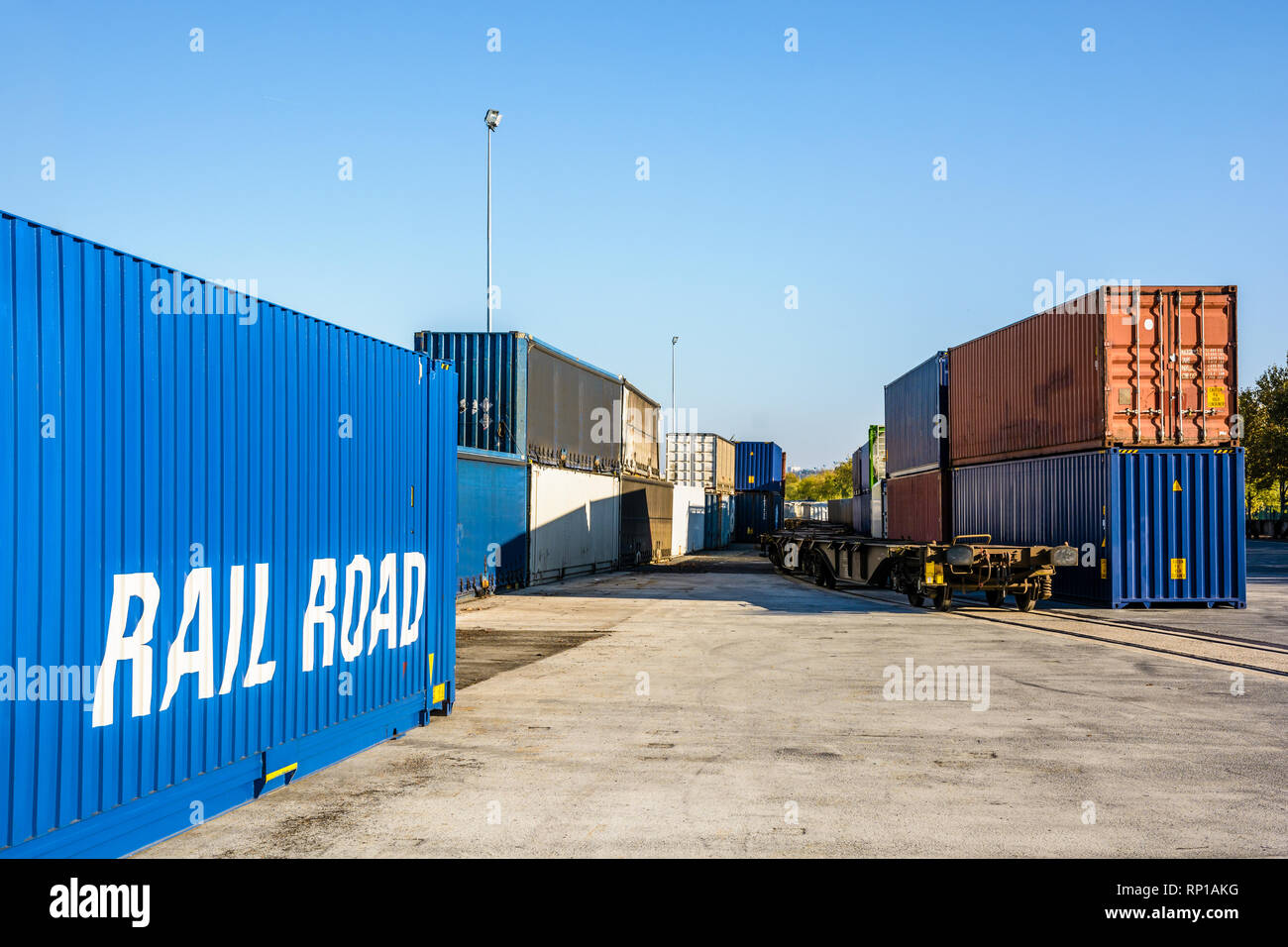 Container in attesa su una piattaforma della ferrovia lungo un treno merci in un porto fluviale nei sobborghi di Parigi, Francia. Foto Stock