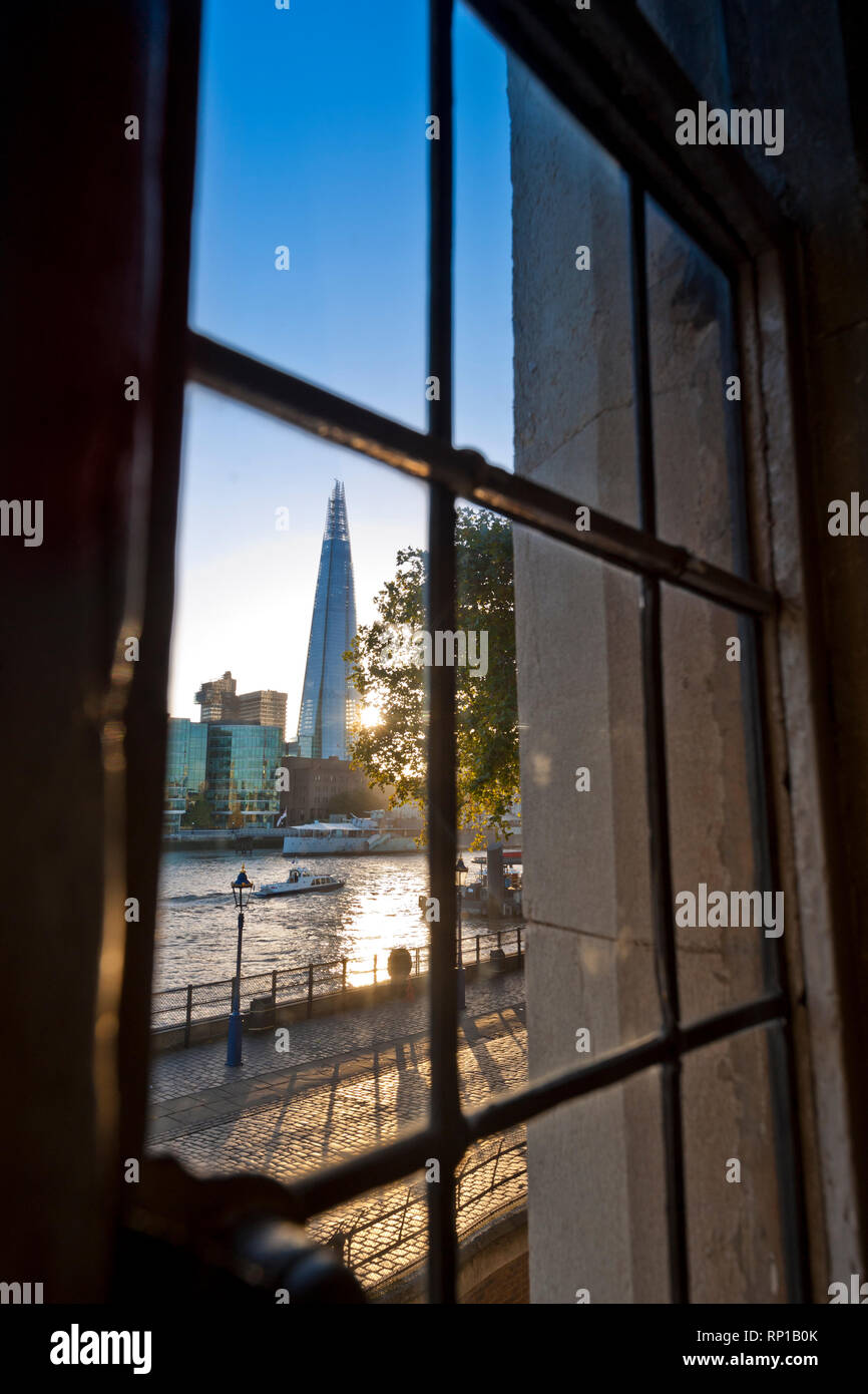 Il London Shard e il fiume Tamigi al tramonto visto attraverso la storica con piombo finestra di luce presso la Torre di Londra London City CE3 Foto Stock