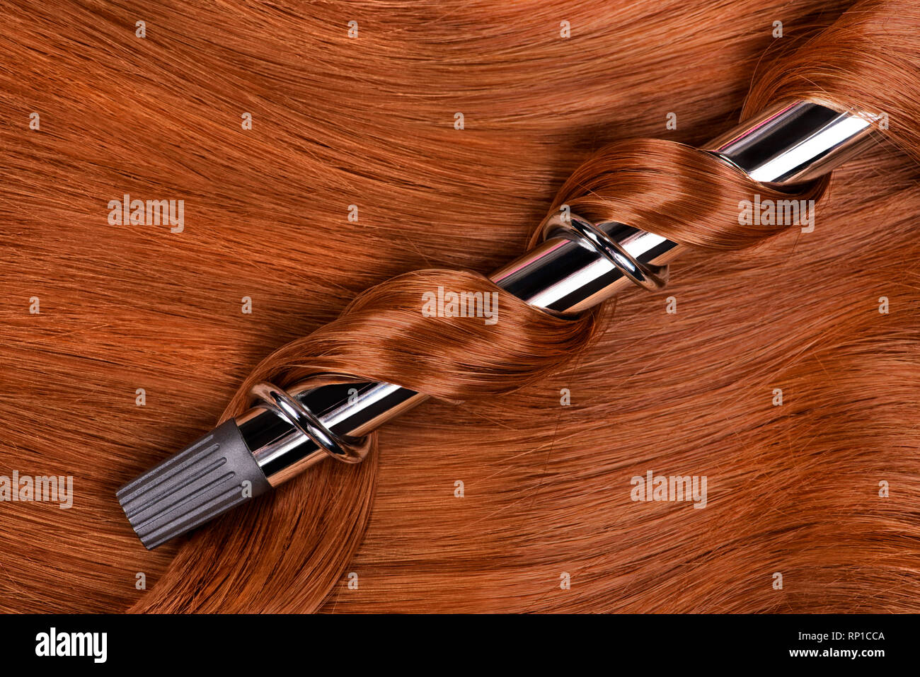 Lunghi capelli rossi con ferro arricciacapelli Foto Stock