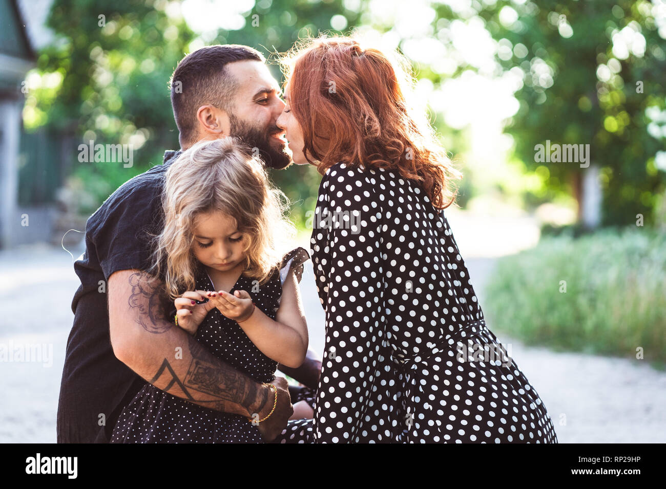 Amare i genitori a piedi con la loro figlia piccola Foto Stock