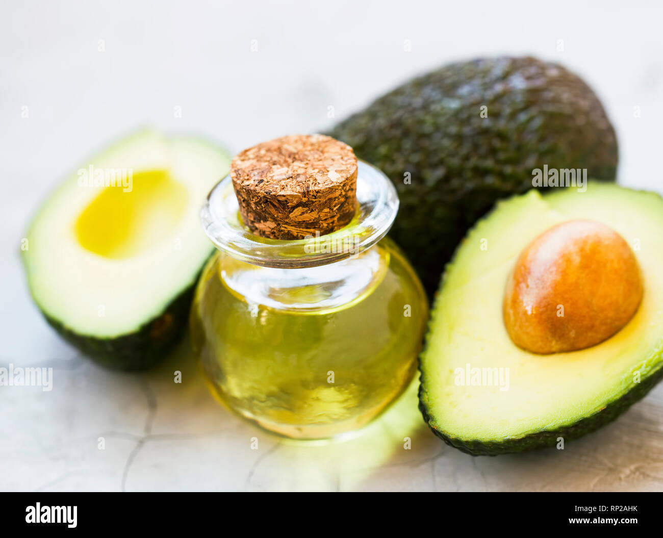 Olio di Avocado bottiglia con gli avocadi frutti, grassi sani closeup olio Foto Stock