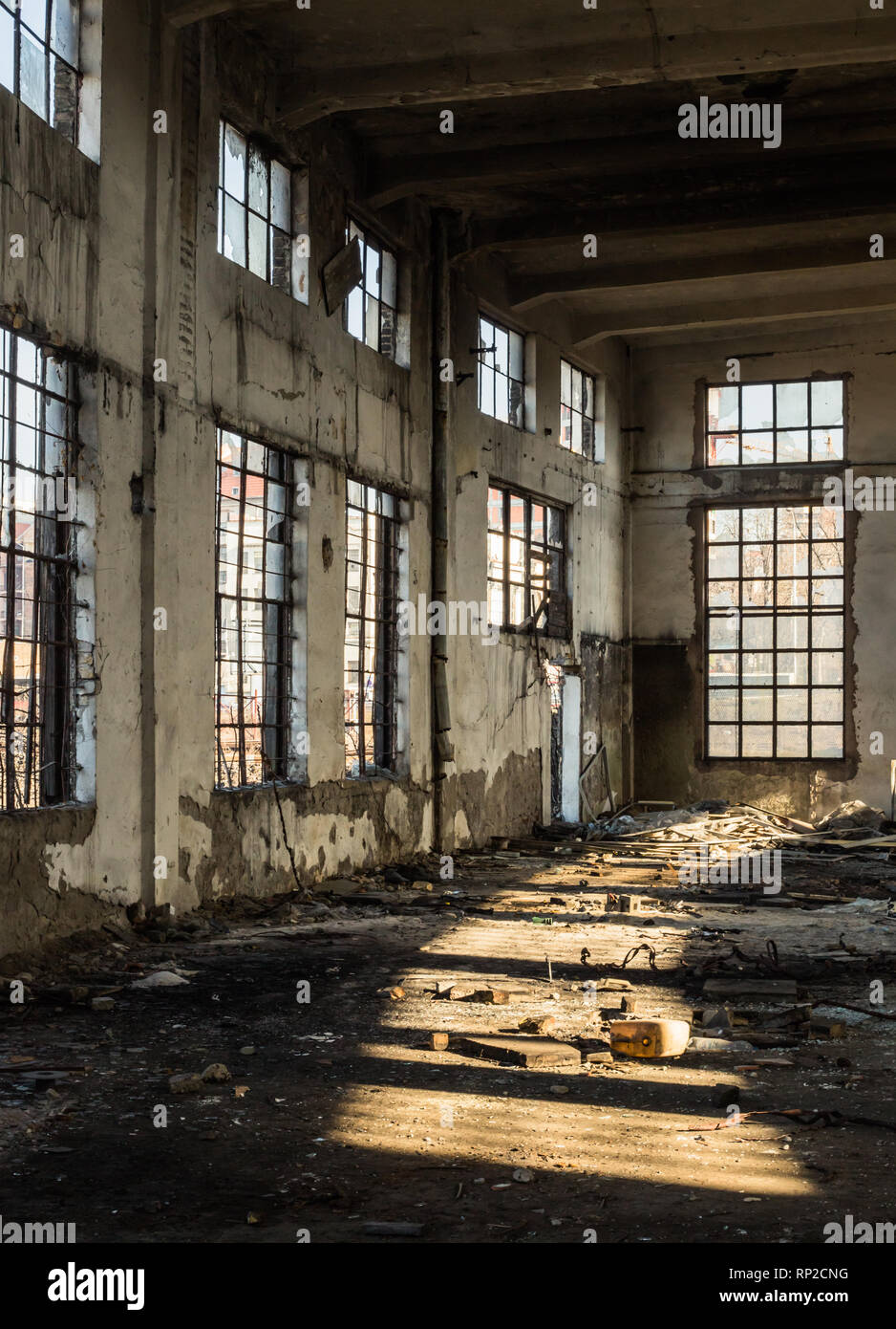 Interno di un vecchio edificio abbandonato alleggerito attraverso le finestre rotte Foto Stock