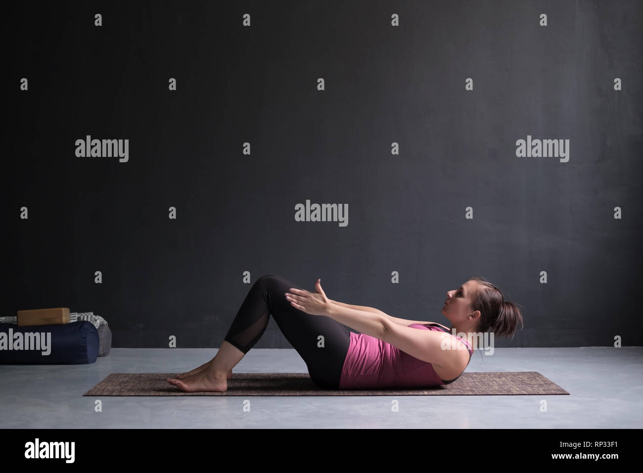 Giovane donna a praticare Yoga asana Ardha Navasana esercitano allo studio di yoga Foto Stock