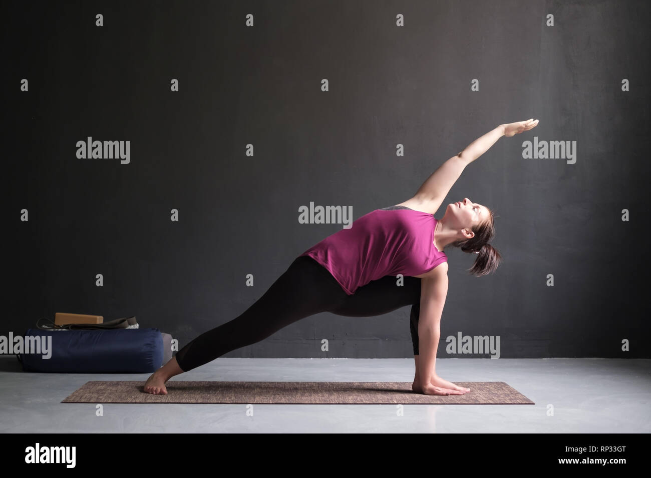 Donna facendo la Posizione laterale ad angolo di postura, Utthita Parsva Konasana. Foto Stock