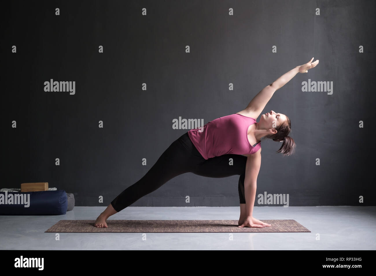 Donna facendo la Posizione laterale ad angolo di postura, Utthita Parsva Konasana. Foto Stock