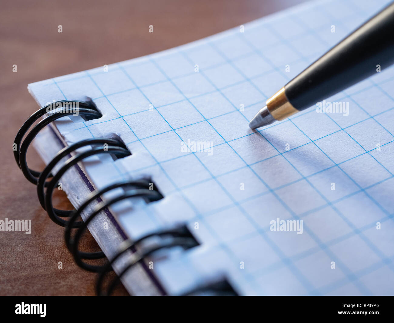 Extreme macro closeup immagine della penna con notebook squadrato fasciate con spirale Foto Stock