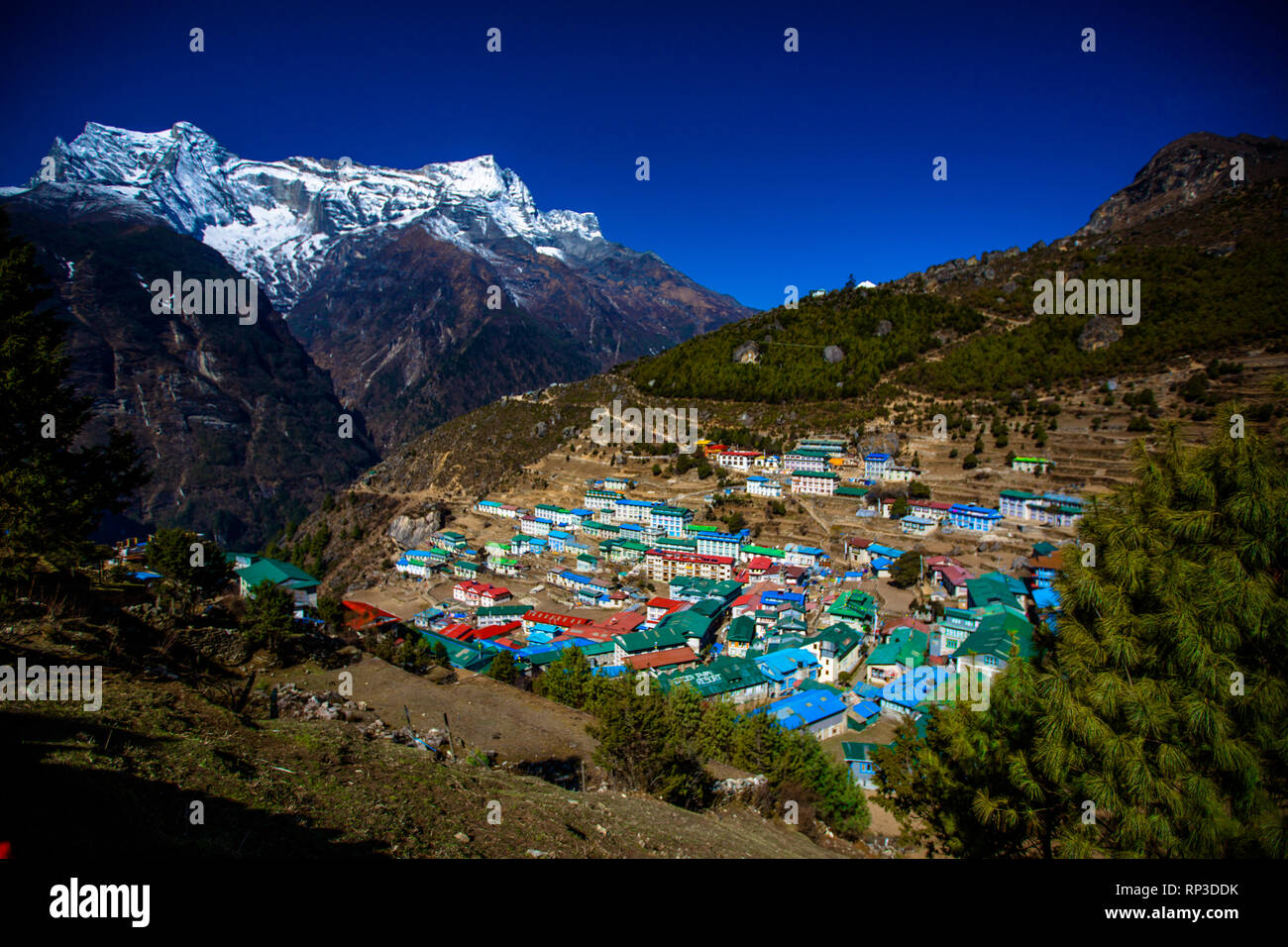 Montagne innevate sedersi graziosamente dietro la bellissima Namche, Himalaya, Nepal Foto Stock