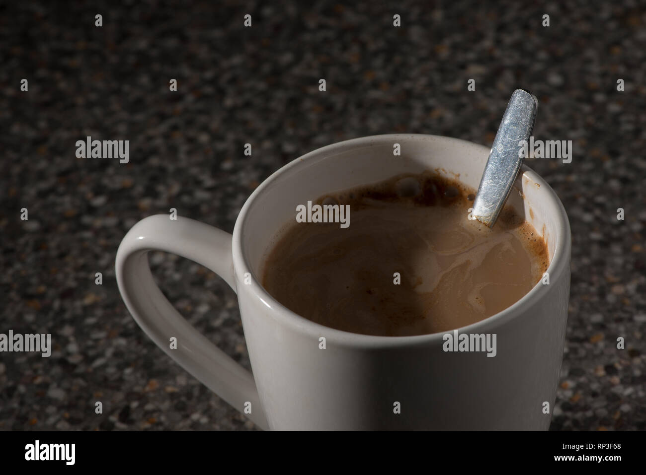 Cerchio bianco della tazza di caffè la tazza con il cucchiaio e maniglia, apparentemente rendendolo un sapore migliore e significativamente più intensa Foto Stock