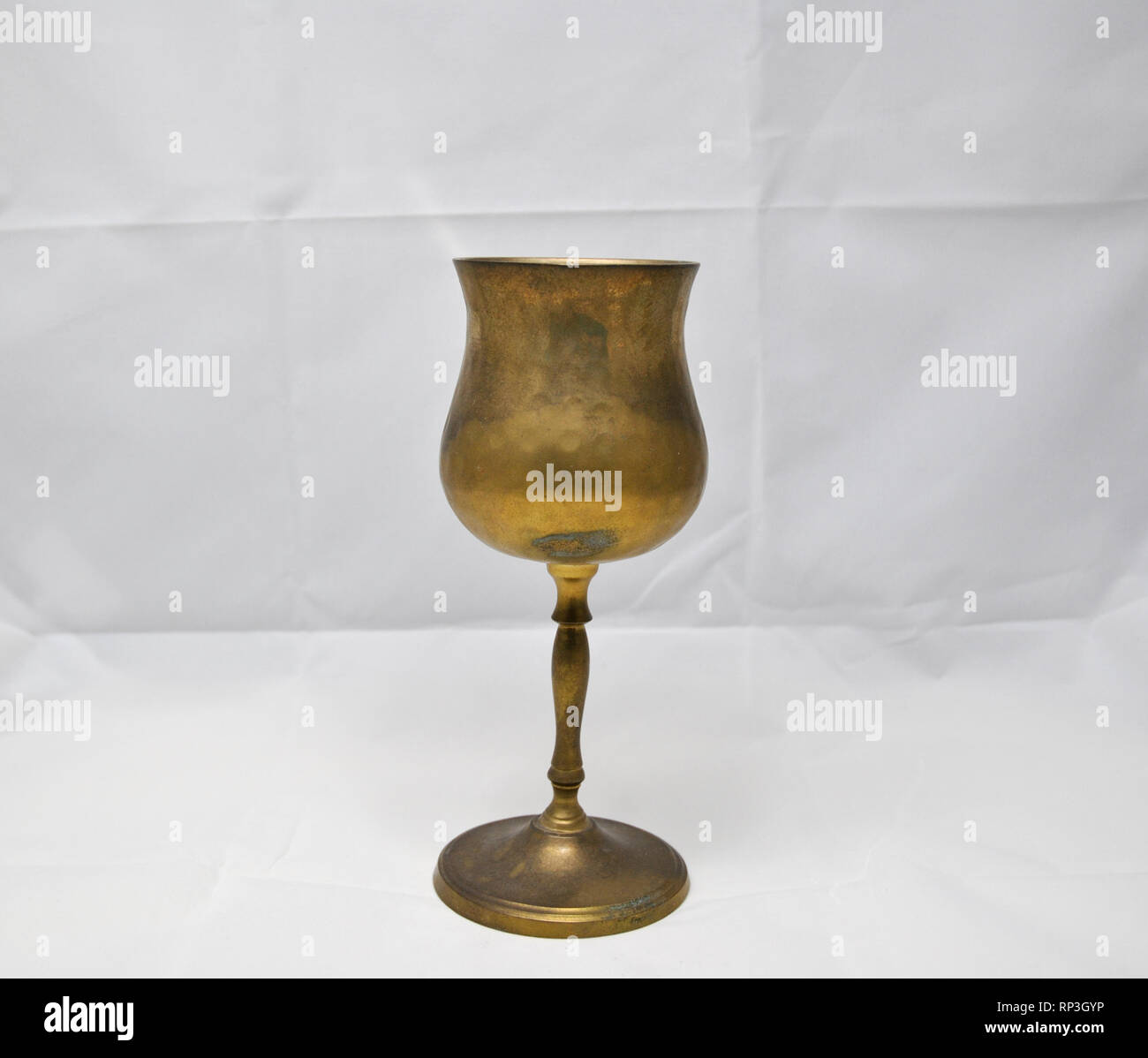 Un vino di ottone cup contro uno sfondo bianco Foto Stock