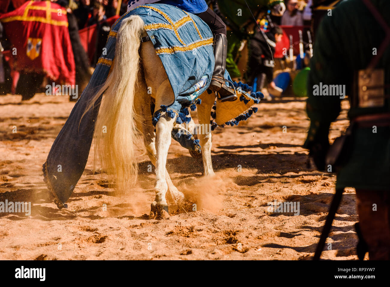 Dettaglio delle gambe dei cavalli al galoppo adornata come supporti medievale montati da cavalieri durante un festival. Foto Stock