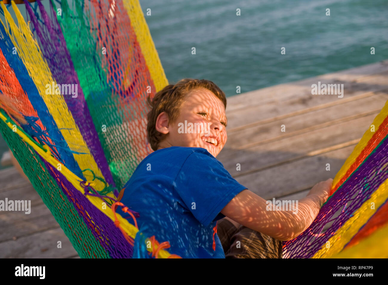 Ragazzo in amaca multicolore Foto Stock