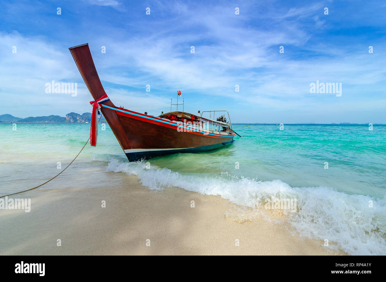 La barca di legno parcheggiato sul mare, spiaggia bianca su un cielo blu chiaro, mare blu Foto Stock