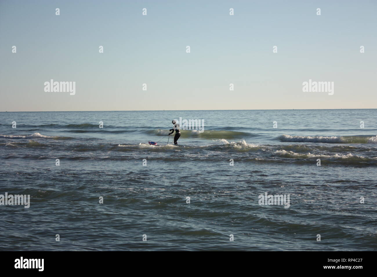 Uomo immerso nella pesca in mare e raccoglie tellines o vongole o altri frutti di mare su una giornata invernale Foto Stock
