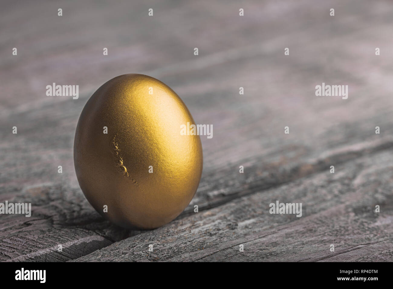 Sfondo di Golden Egg su una superficie in legno Foto Stock