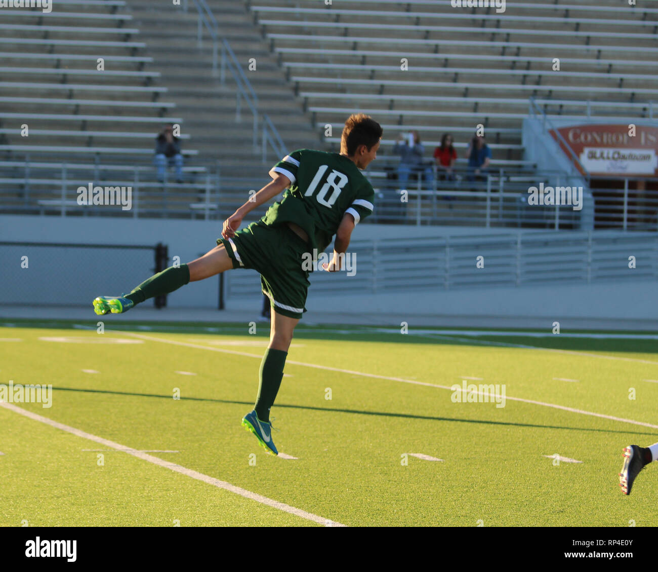 Il calciatore è sospeso in aria dopo salta in alto per la testa a sfera durante un boys high school gioco a Woodforest Bank Stadium di Shenandoah, Tex. Foto Stock Il calciatore è sospeso in aria dopo salta in alto per la testa a sfera durante un boys high school gioco a Woodforest Bank Stadium di Shenandoah, Tex. Foto Stock