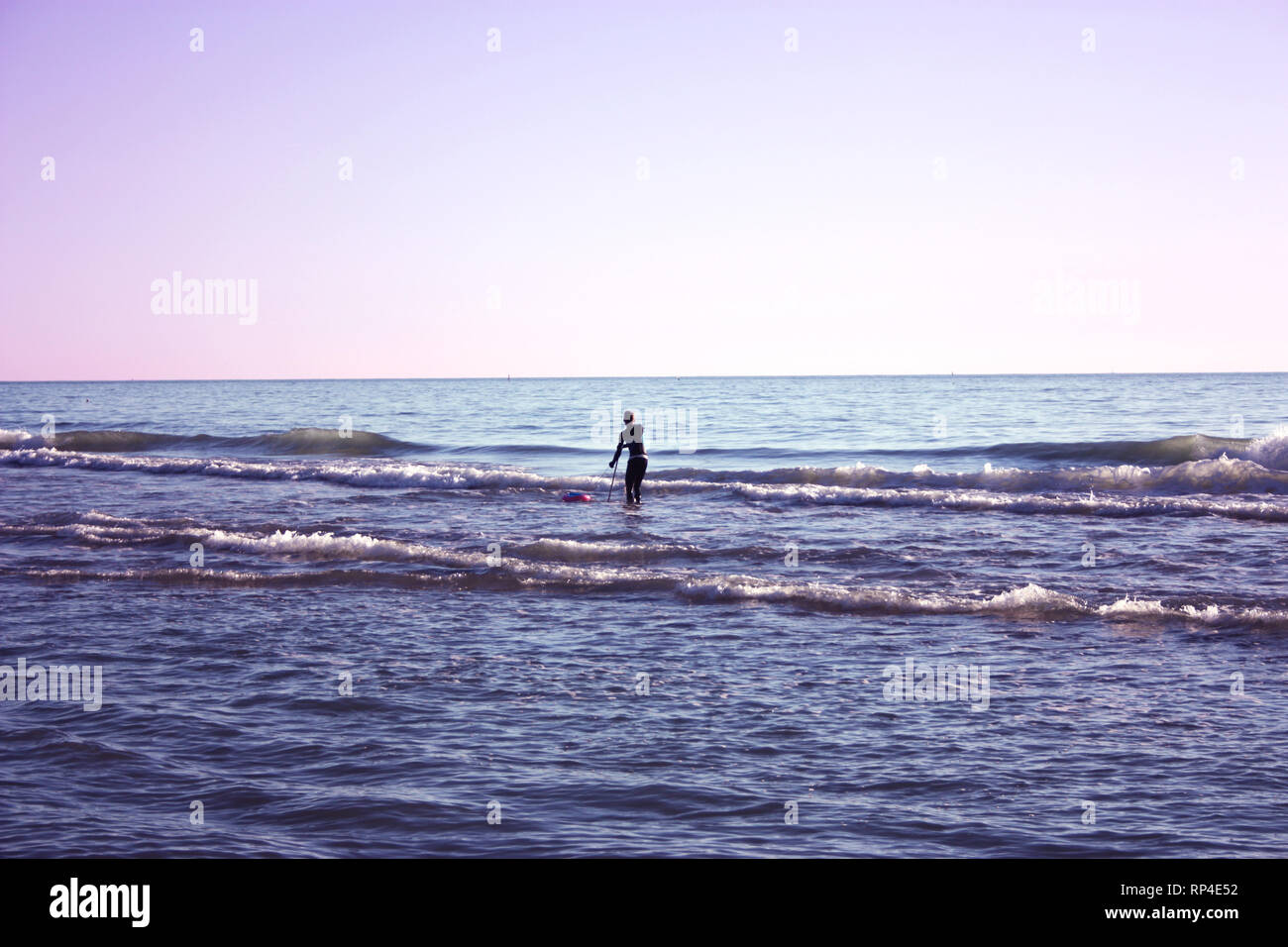 Uomo immerso nella pesca in mare e raccoglie tellines o vongole o altri frutti di mare su una giornata invernale Foto Stock