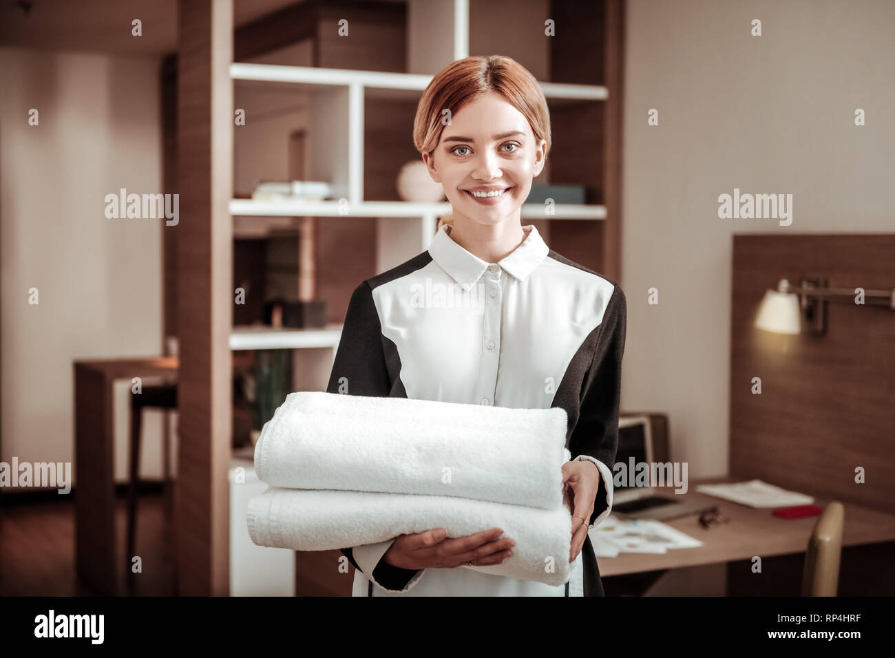 Piacevole giovane bionda cameriera hotel azienda asciugamani bianchi Foto Stock