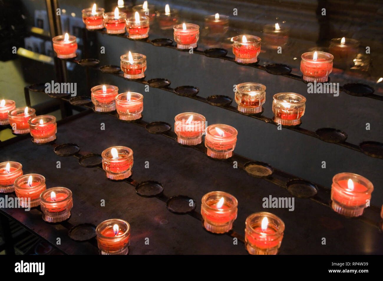 Acceso candele votive all'interno di una chiesa Foto Stock