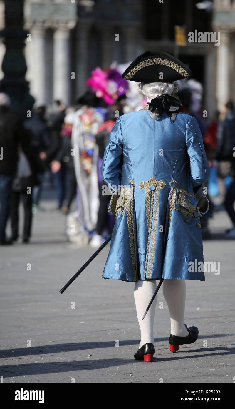 Uomo mascherato con parrucca bianca e blu elegante nobile veneziano vestito in Piazza San Marco durante il Carnevale di Venezia Foto Stock