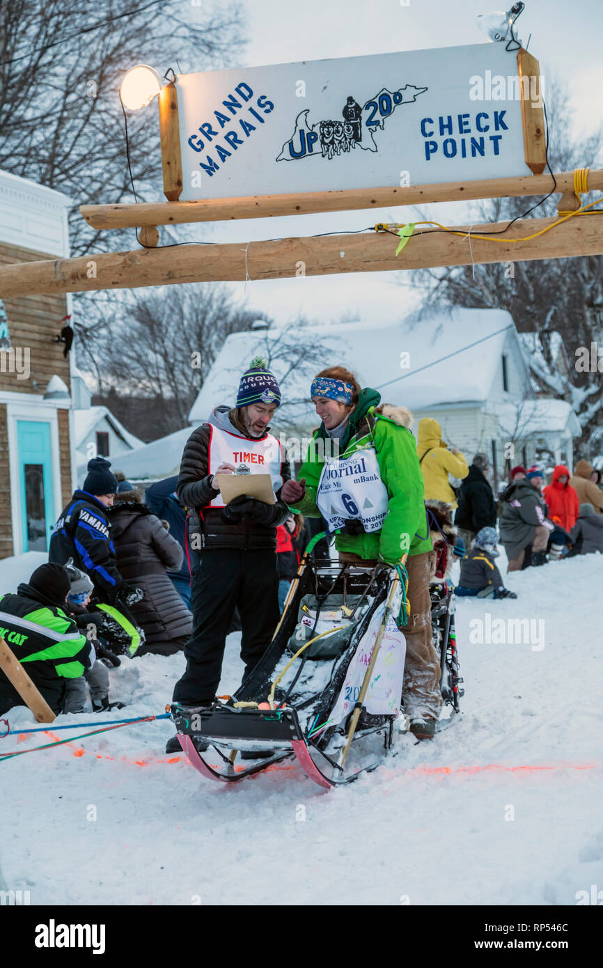 Grand Marais, Michigan - Dogsled racer Erin Redington controlli in con un ufficiale di gara al giro di boa della fino 200, un annuale 238 Miglia Race da Foto Stock