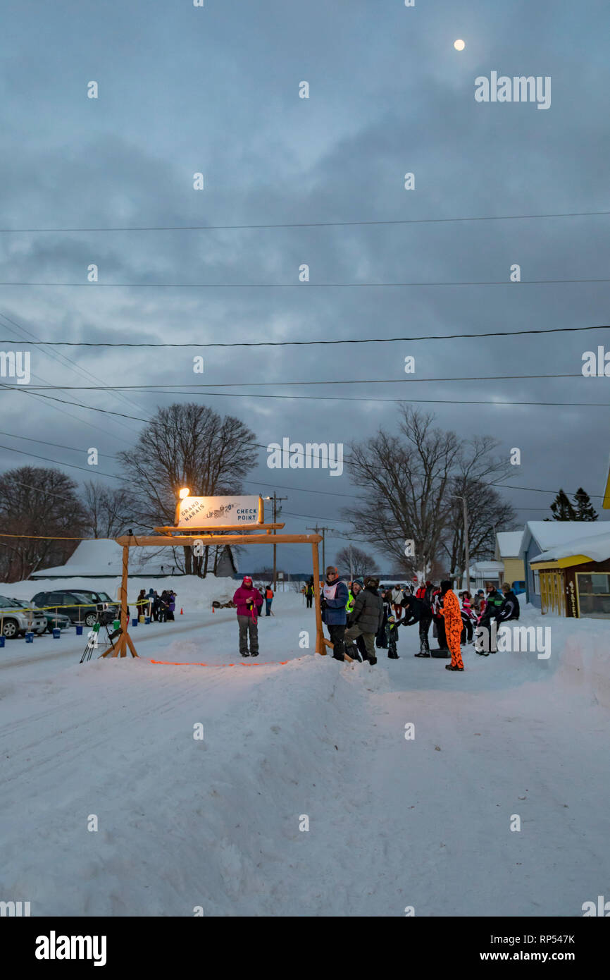 Grand Marais, Michigan - Sotto un quasi-luna piena, degli ufficiali di gara e gli spettatori attendere dogsled racers al giro di boa di fino a 200. La UP 20 Foto Stock