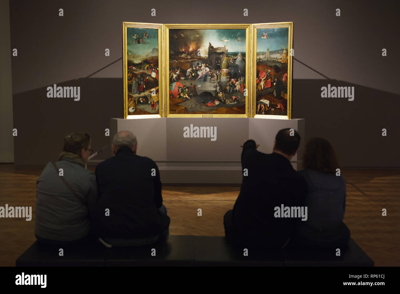 I visitatori di fronte all'altare trittico "Tentazione di Sant Antonio' olandese da pittore rinascimentale Hieronymus Bosch (1490-1500) visualizzato nel Museo Nazionale di Arte Antica (Museu Nacional de Arte Antiga) a Lisbona, Portogallo. Foto Stock