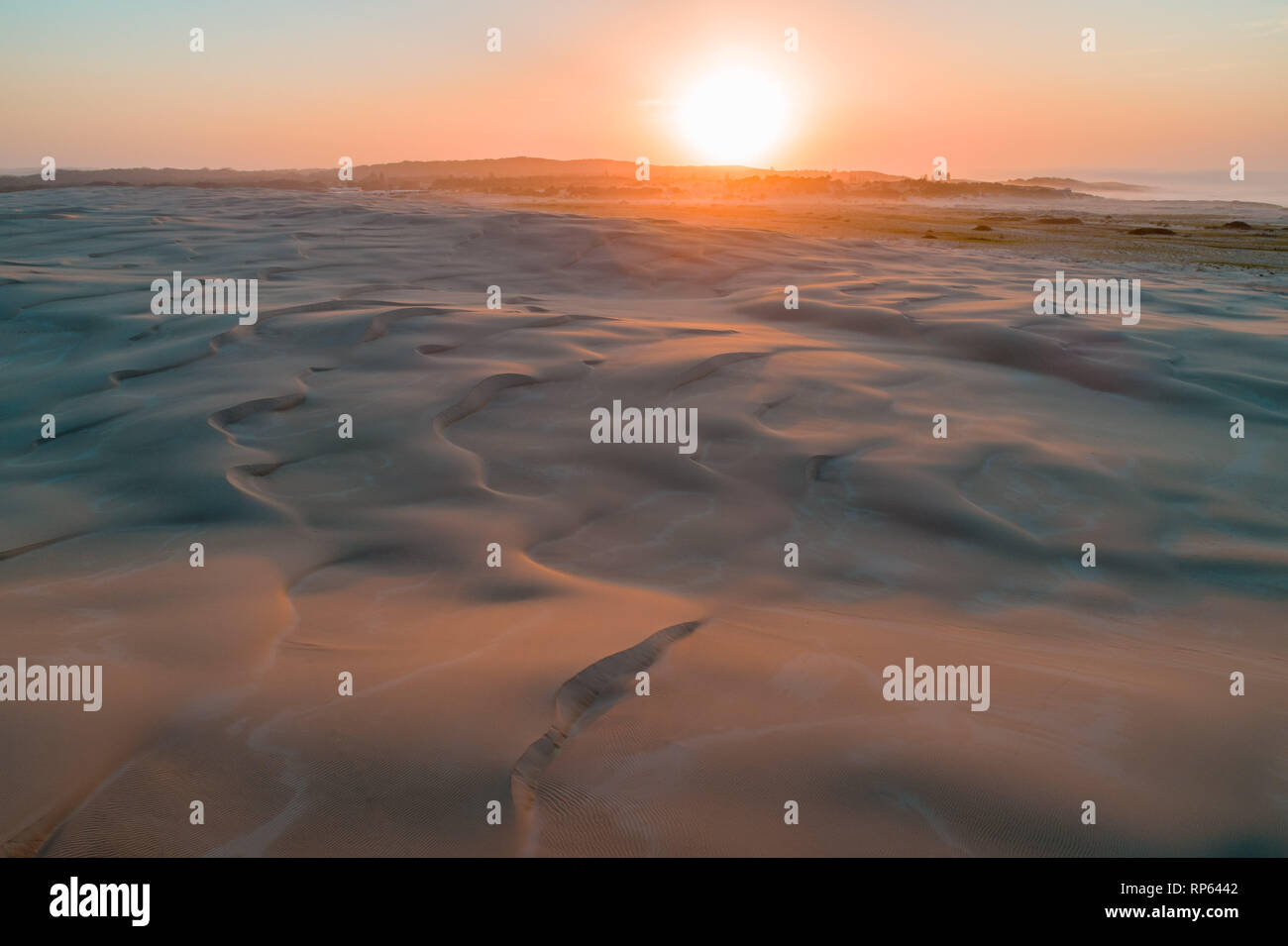 Alba sulle immacolate dune di sabbia vicino all'oceano. Foto Stock