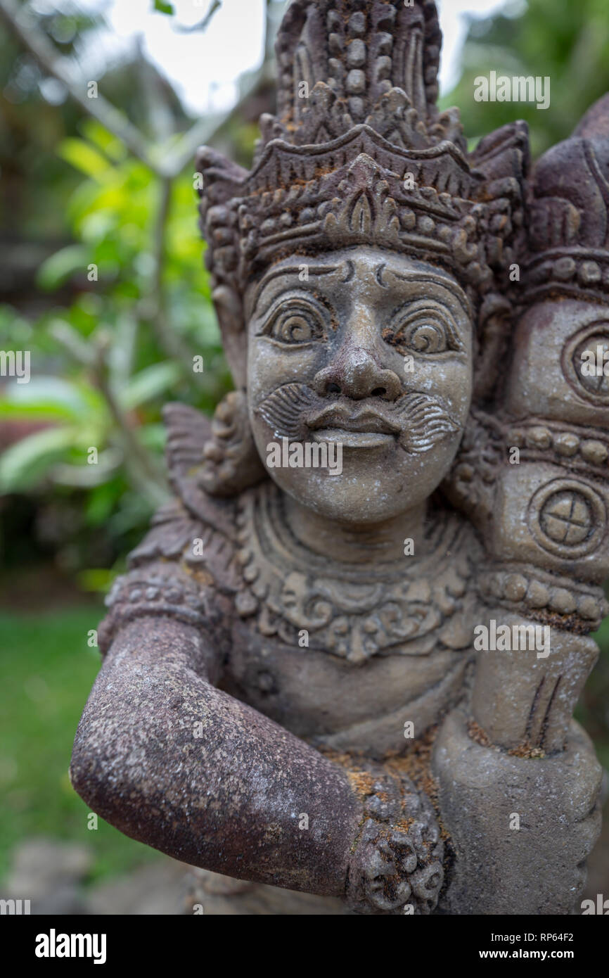 Primo piano della pietra scolpita la statua di un dio sul muro del tempio indù di Bali Foto Stock