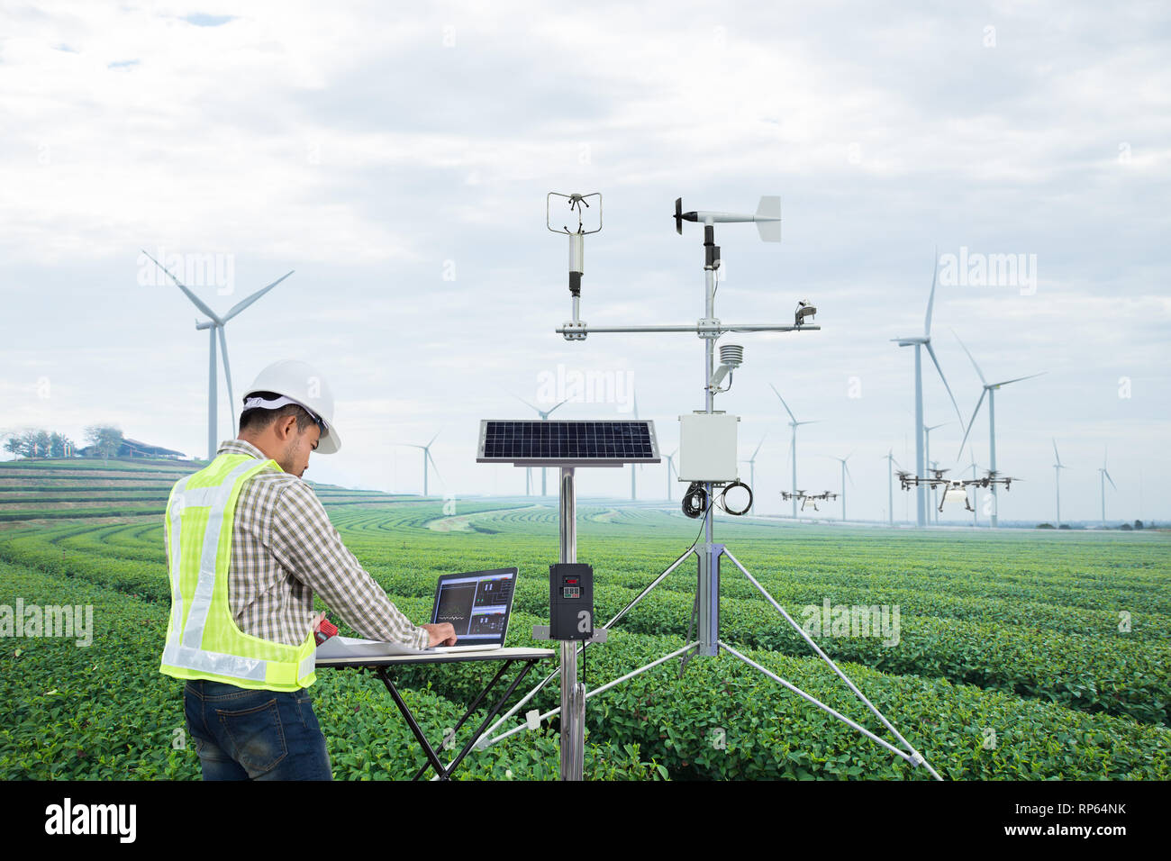 Ingegnere utilizzando computer tablet di raccogliere dati con strumenti meteorologici per misurare la velocità del vento, temperatura e umidità e di cella solare o di sistema Foto Stock