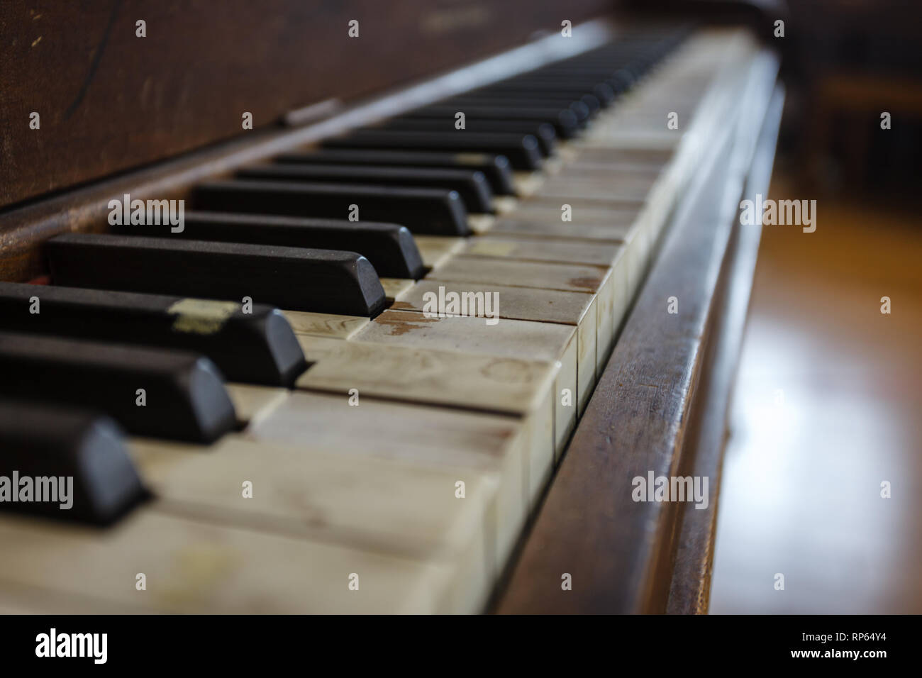 Primo piano di una vecchia tastiera per pianoforte che ha visto giorni migliori Foto Stock