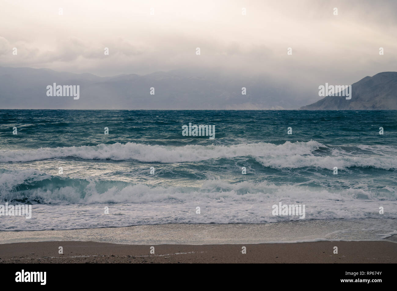 Grandi onde nel mare e spiaggia ghiaiosa Foto Stock