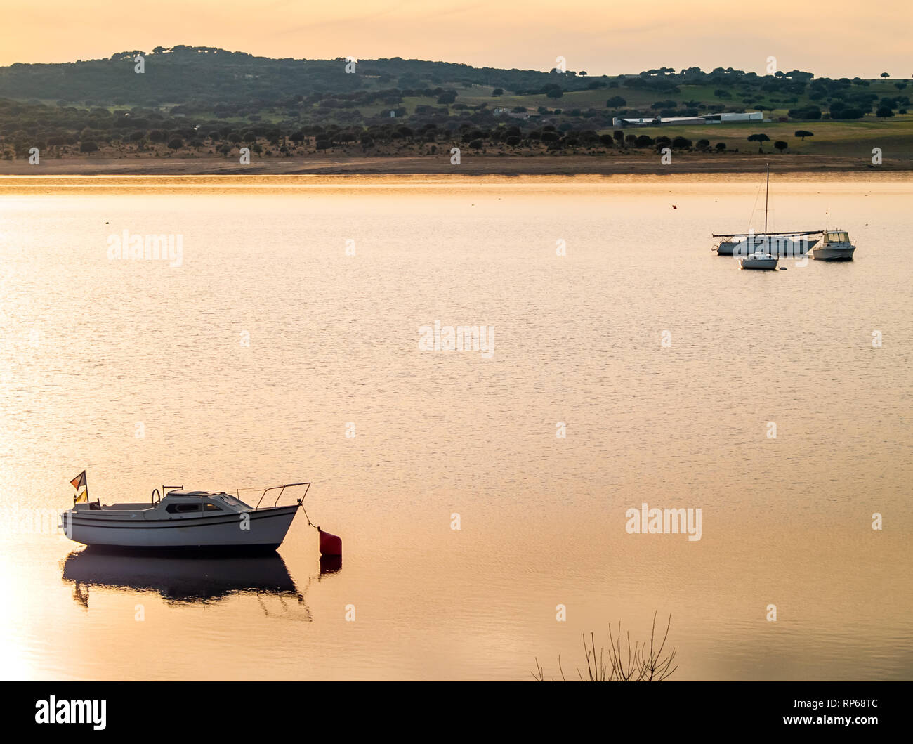 Barche sul lago al tramonto, ormeggiato con una boa e calma acqua nel serbatoio di La Maya (Salamanca) Foto Stock