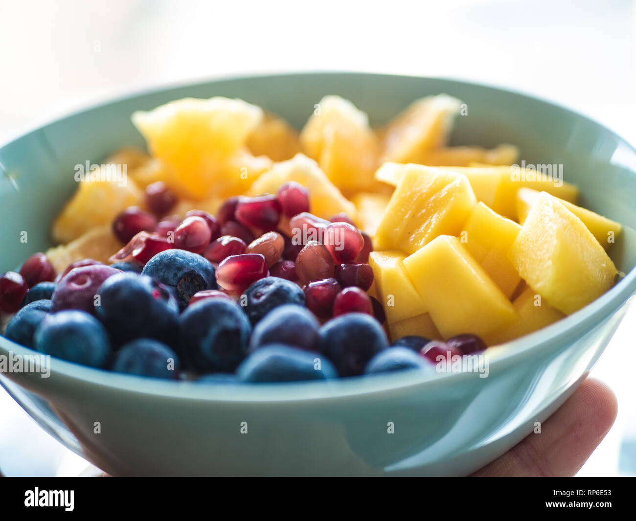 Mangiare sano: una deliziosa tazza di mirtilli, Mango und melograno Foto Stock