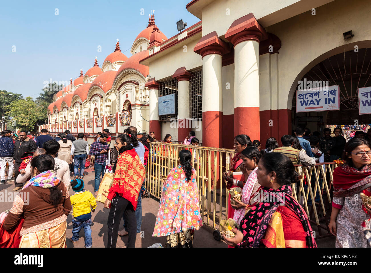 Il Dakshineswar Kali Tempio sulle rive del Fiume Hooghly con gente locale entrando e uscendo in una giornata di sole con cielo blu. Foto Stock