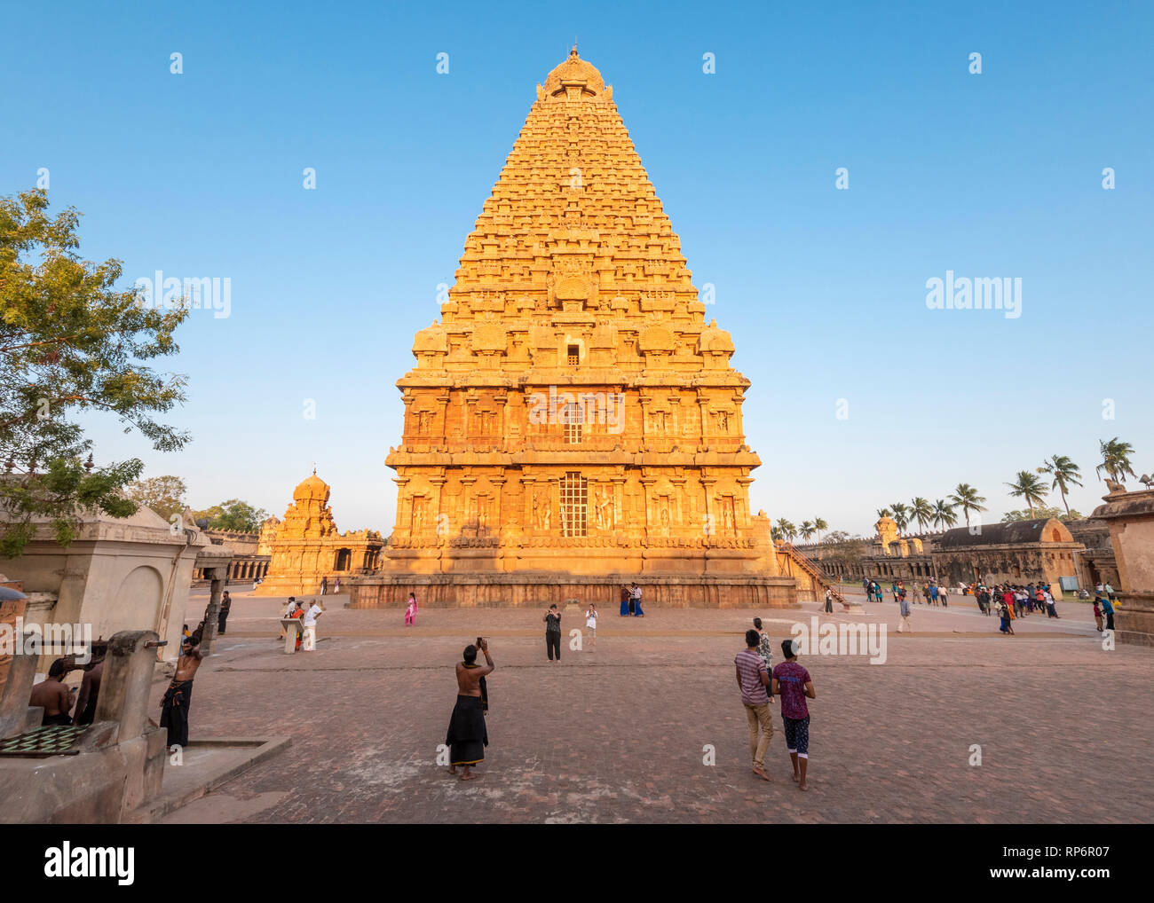 Ampio angolo di visione del tempio Brihadishvara a Thanjavur al tramonto con i turisti e la gente del luogo la visita a piedi con un cielo blu. Foto Stock