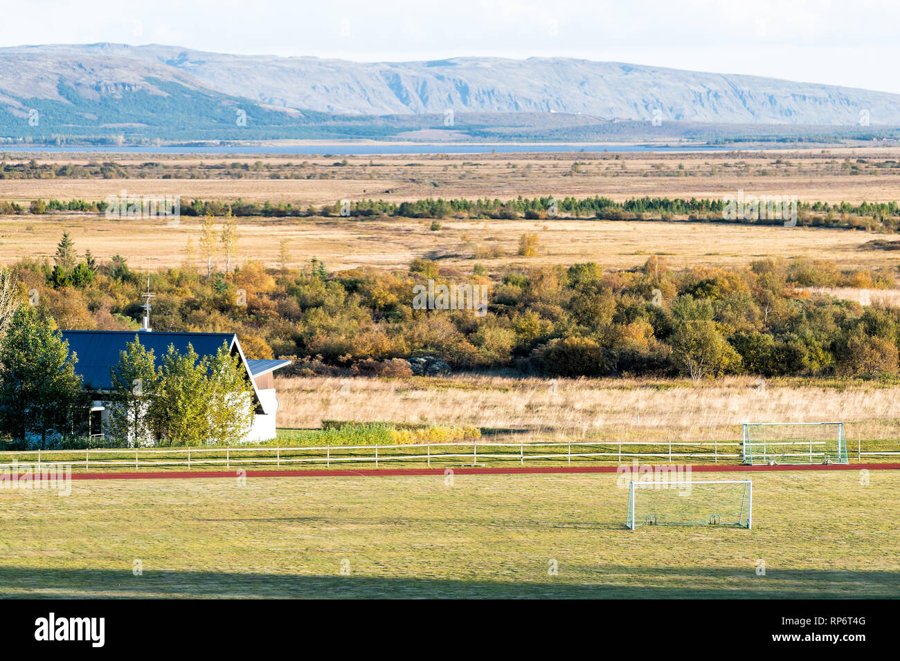 Antenna del paesaggio ad alto angolo di visione della casa e campo di calcio durante il giorno in un cerchio d'oro in Islanda con agriturismo a Laugarvatn villaggio con soccer fie Foto Stock