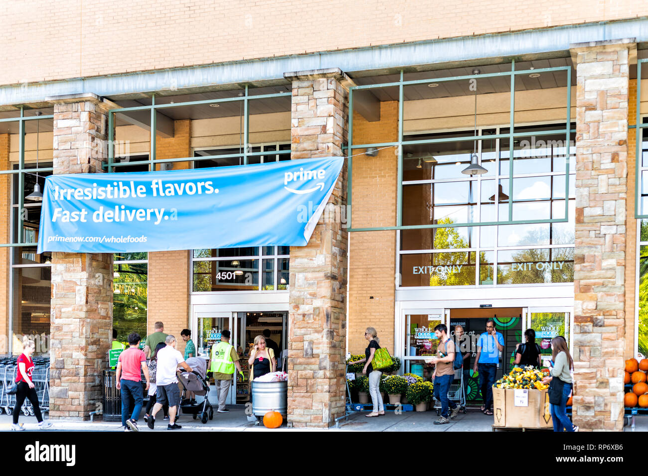 Fairfax, Stati Uniti d'America - 29 Settembre 2018: Whole Foods Market segno su edificio esterno in città in Virginia con persone e blue Amazon primo segno di consegna da Foto Stock