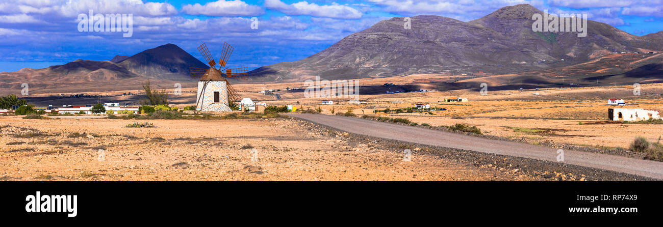 Fuerteventura travel - scenic paesaggi dell'isola vulcanica, vista con mulino a vento tradizionale. Isole Canarie Foto Stock