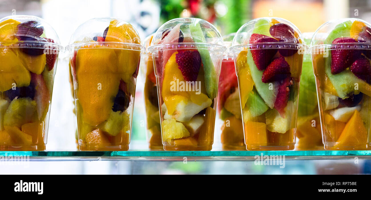 Insalata di frutta in bicchieri di plastica da asporto. Fette di frutta organica e bacche, snack sani per andare, copia dello spazio. Foto Stock