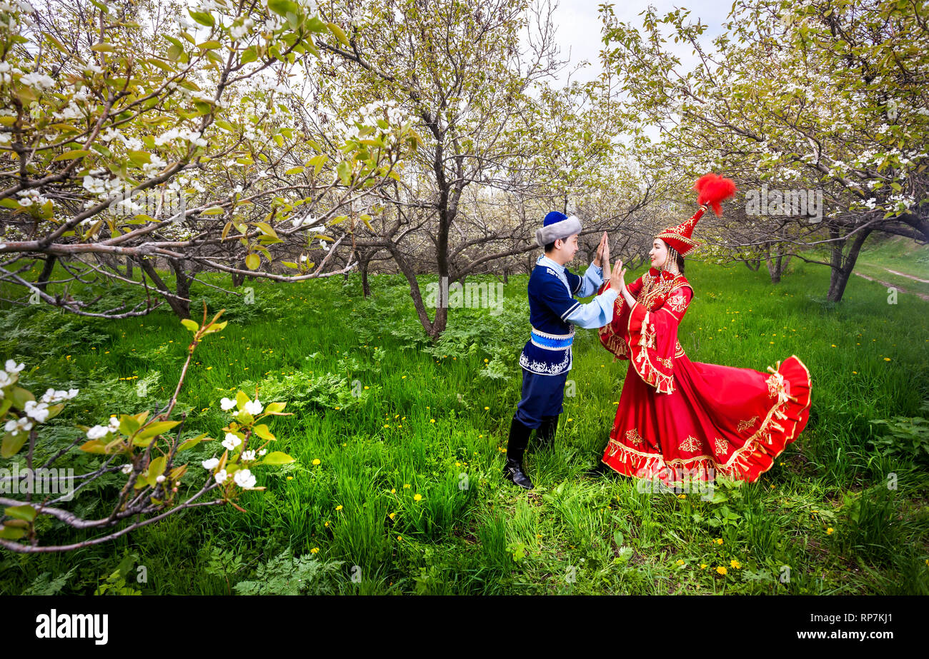 Matura in kazako costume tradizionale in fioritura primaverile apple giardino di Almaty in Kazakistan e in Asia centrale Foto Stock