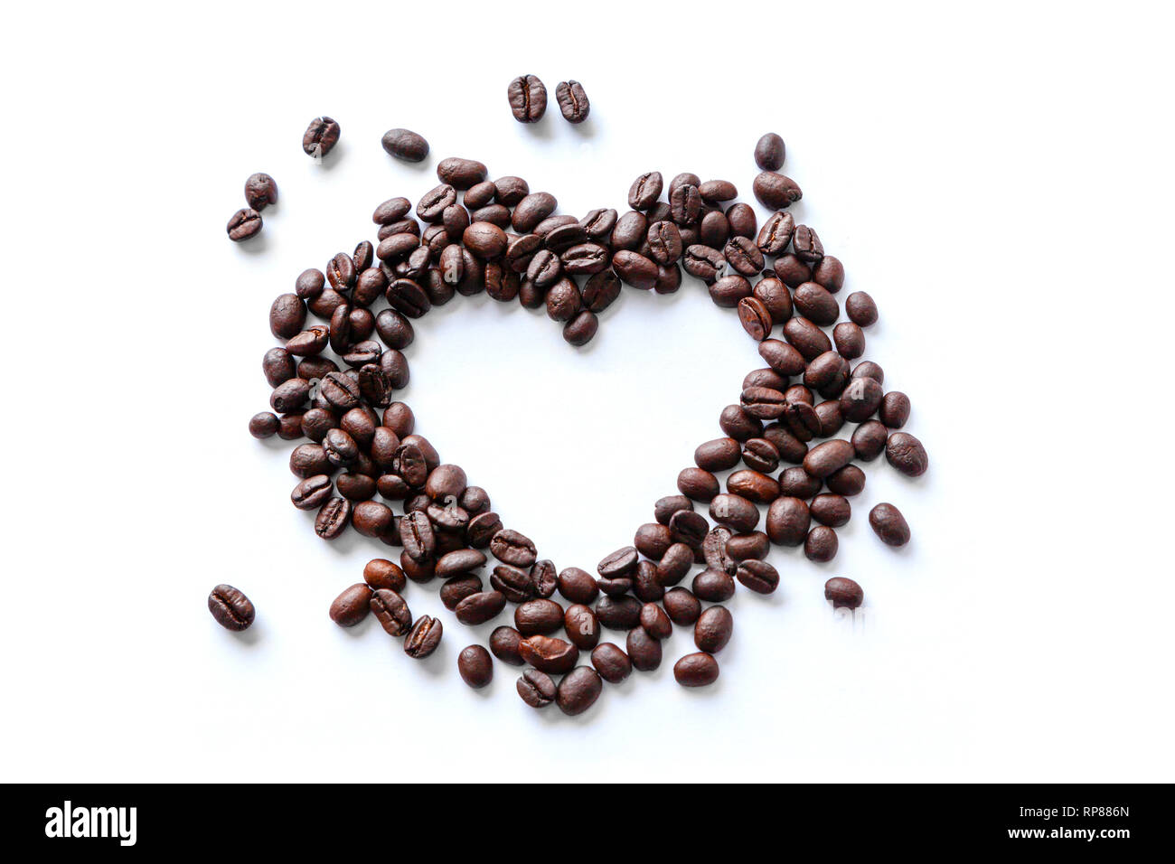 Amore per il caffè espresso in schizzi di caffè in grani a forma di cuore isolato su sfondo bianco Foto Stock