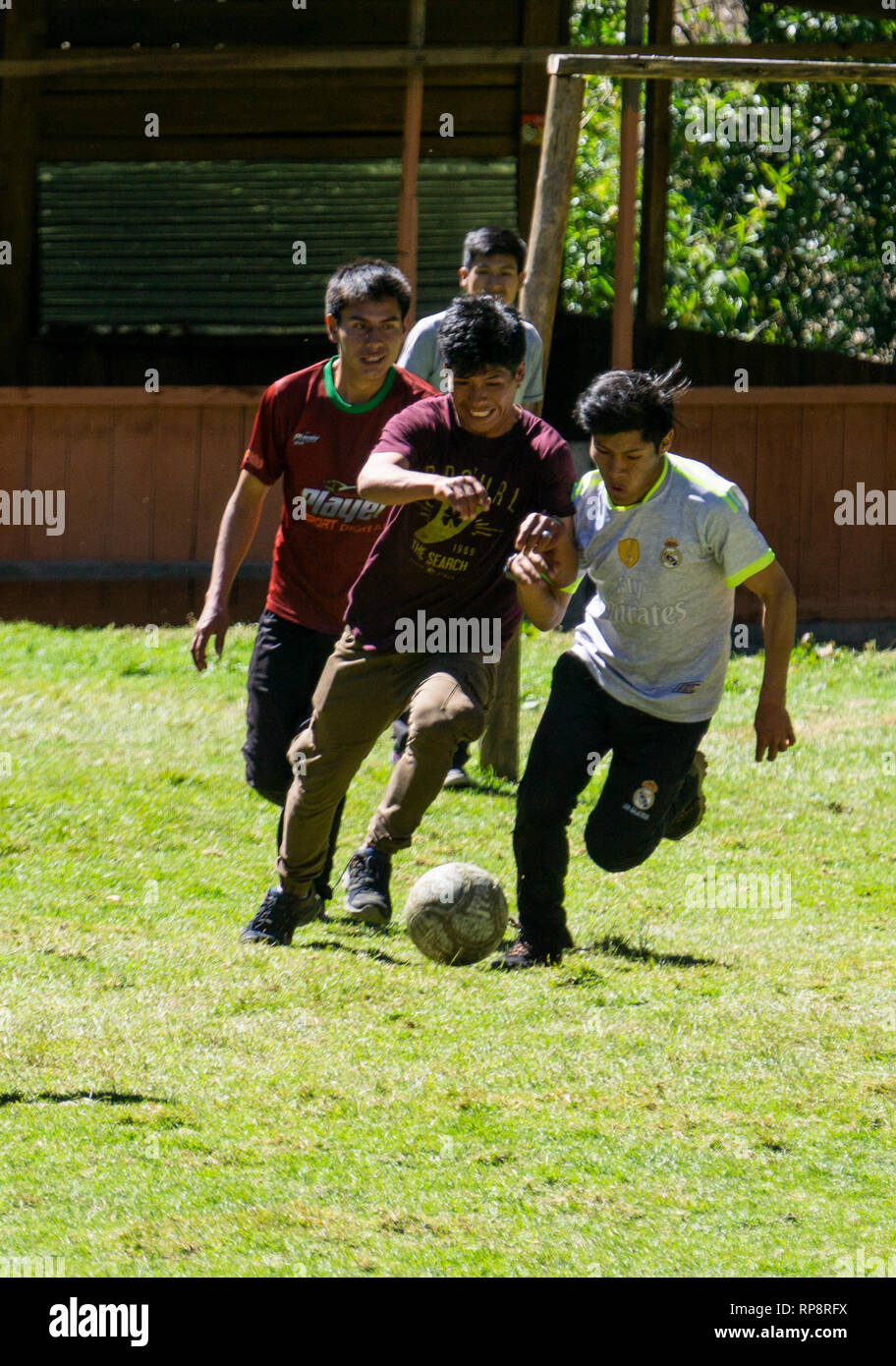 Ragazzi adolescenti play futbol (calcio) nel sole di mezzogiorno in Perù. Foto Stock