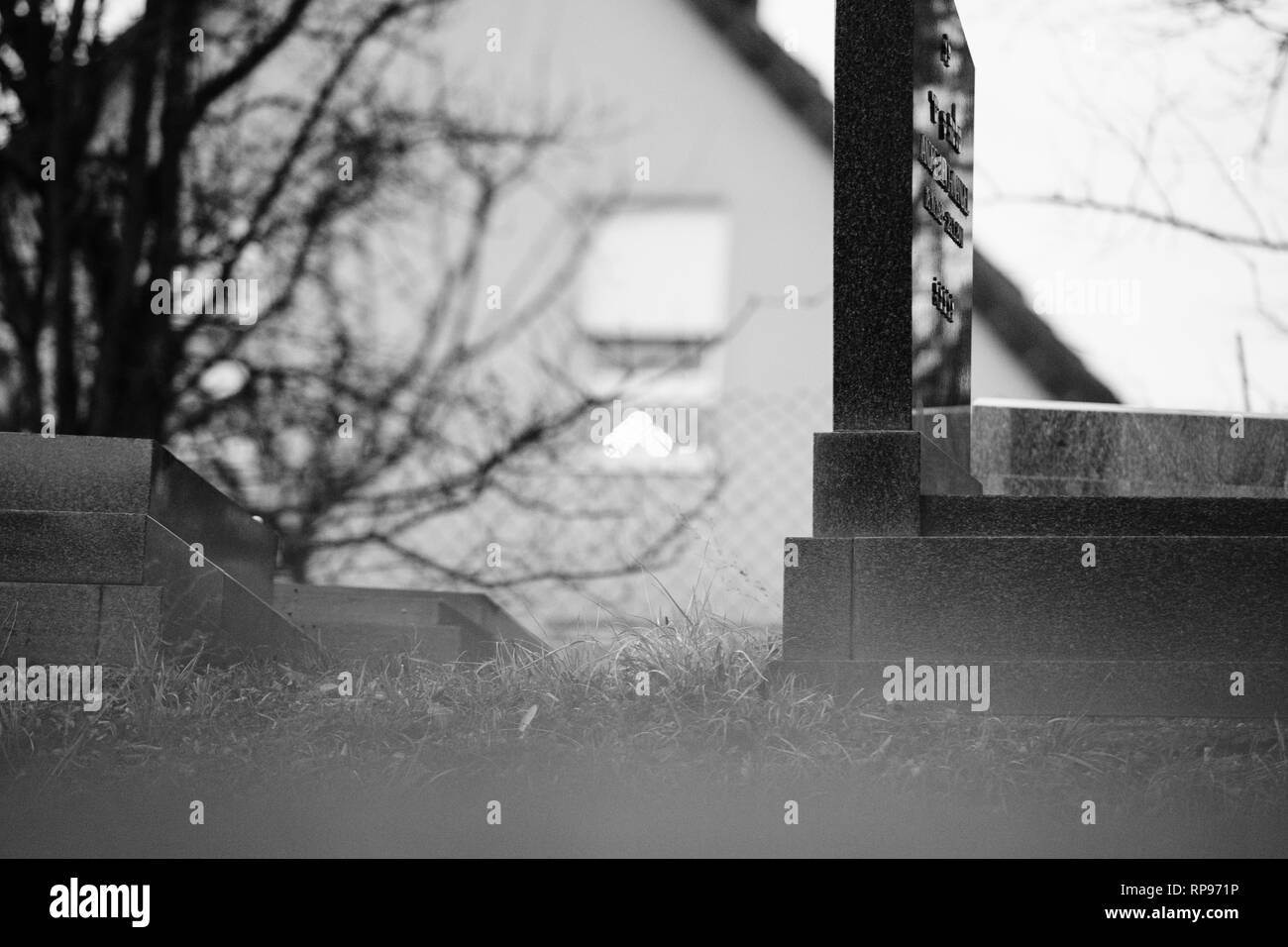 Il Menorah bokeh silhouette nella finestra di una casa vicino al soggetto ad atti vandalici tombe con simboli nazisti in blu spray-dipinte sulle tombe danneggiato - Cimitero Ebraico in Quatzenheim vicino a Strasburgo . Foto Stock