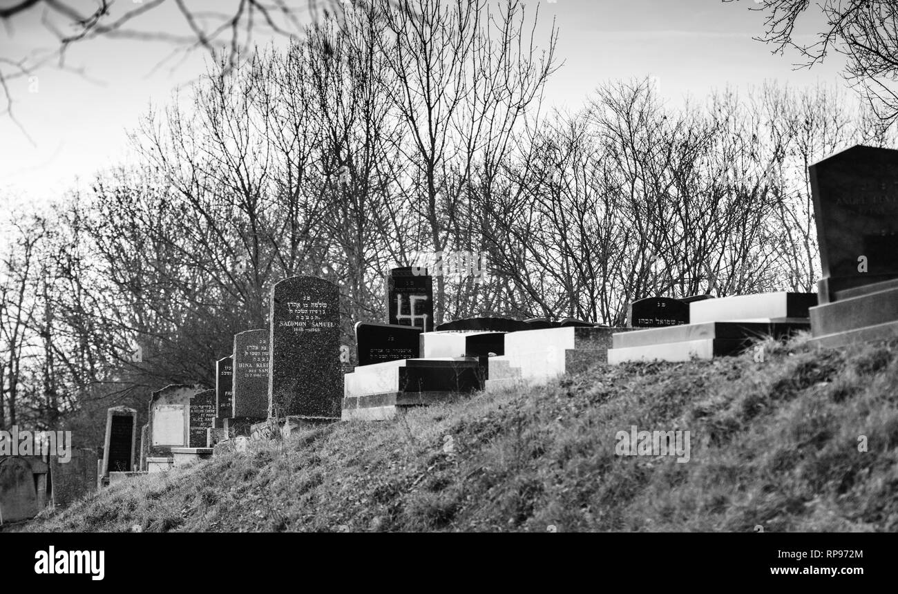 Soggetto ad atti vandalici tombe con svastiche nazista in blu spray-dipinte sulle tombe danneggiato - Cimitero Ebraico in Quatzenheim vicino a Strasbourg - bianco e nero monocromatico Foto Stock