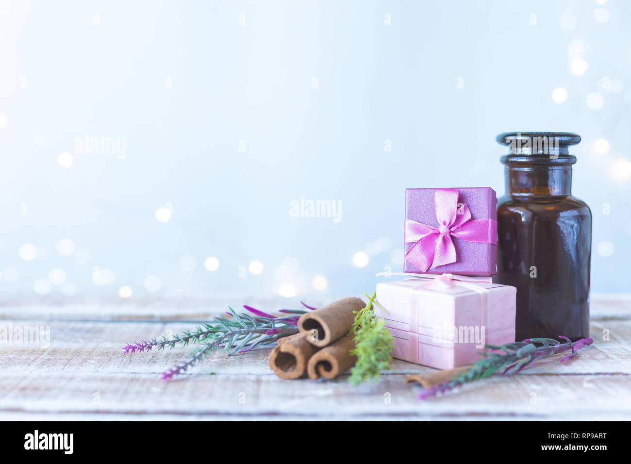 Scatole con doni, un bouquet di fiori, cosmetico olio su una luce blu con sfondo bokeh di fondo. La giornata della donna, madre il giorno del concetto di spazio di copia Foto Stock