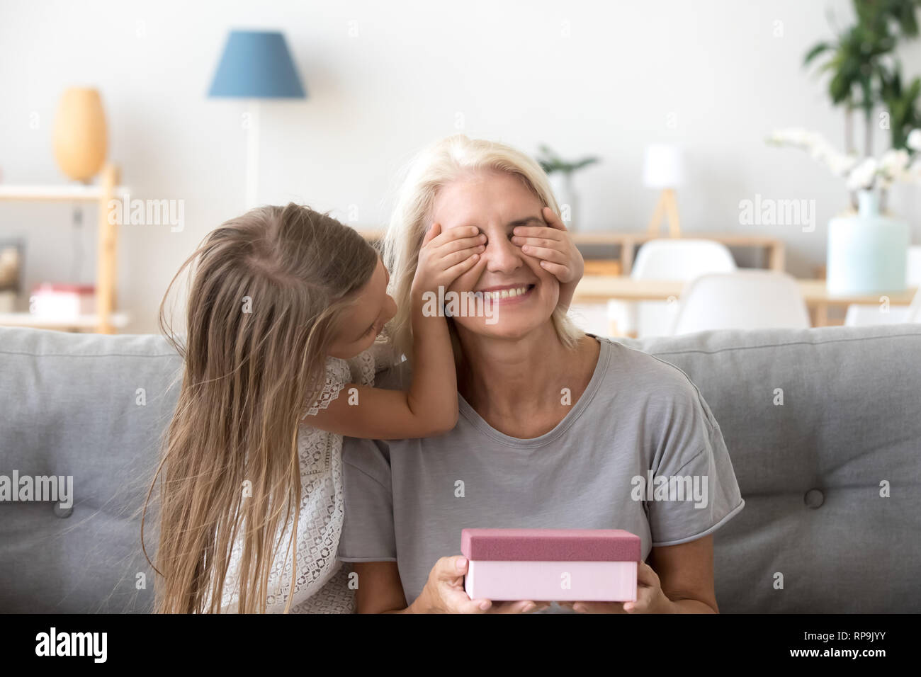 Amare la nipote rendendo la sorpresa di nonna felice Foto Stock