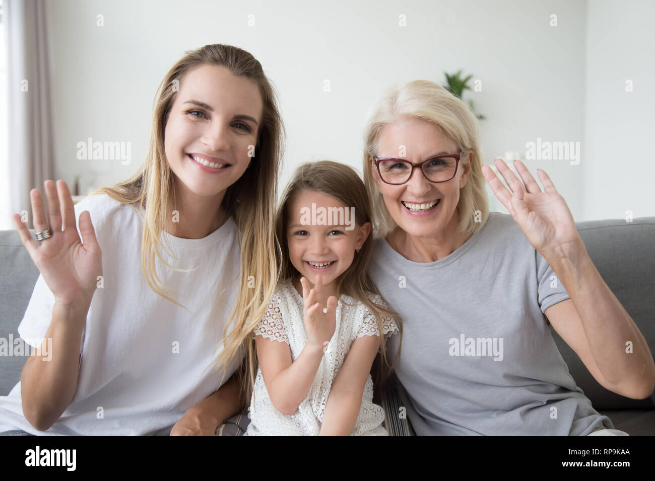 Felice sorridente bambina con la madre e nonna agitando la mano Foto Stock